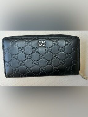 Authentic Gucci GG embossed zip-around wallet in black leather. Made in Italy.